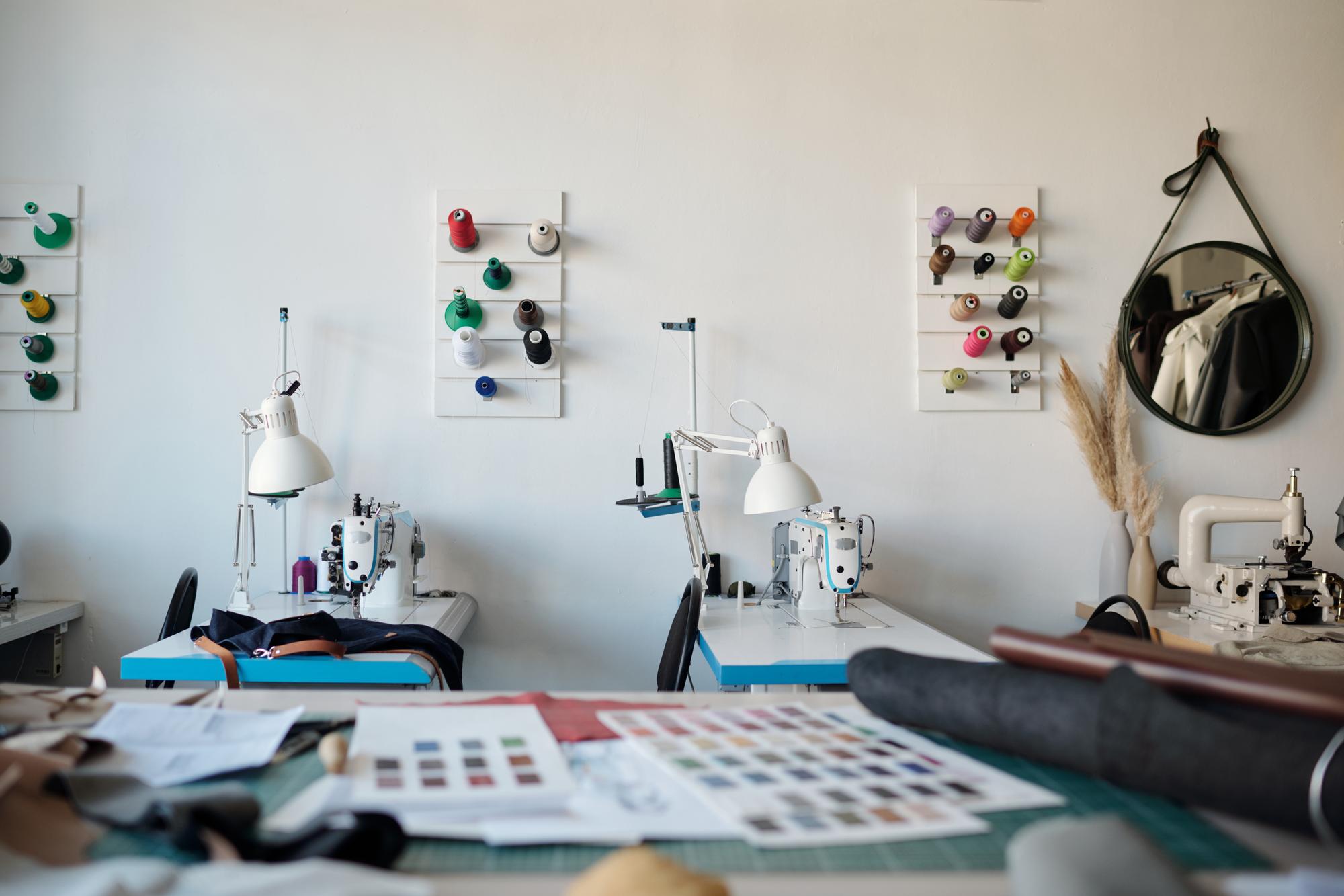 Atelier con postazione per ricamo e monitor con design vettoriale